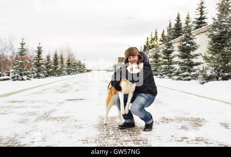 Homme avec chien de race husky en hiver sur la neige Banque D'Images