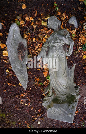 La figure d'un air d'été entouré de feuilles d'automne au cimetière de Morningside, Édimbourg, Écosse, Royaume-Uni. Banque D'Images