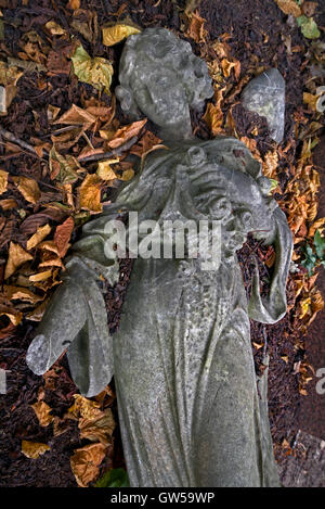 La figure d'un air d'été entouré de feuilles d'automne au cimetière de Morningside, Édimbourg, Écosse, Royaume-Uni. Banque D'Images