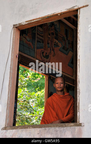 Phnom Chisor temple Khmer, jeune moine à la recherche par la fenêtre Banque D'Images