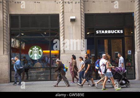 Les piétons se précipitent par l'un des innombrables Starbucks dans Manhattan, New York. Banque D'Images