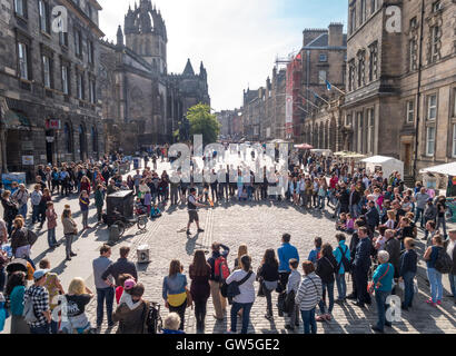 Royal Mile d'Édimbourg. High Street Édimbourg avec fire interprète et un cercle de visiteurs, les touristes à la recherche sur. Banque D'Images