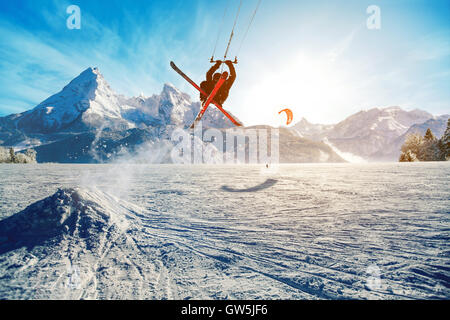 Les jeunes hommes, le ski sur un lac gelé dans les montagnes, dans les rayons du soleil levant, en hiver Banque D'Images