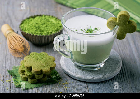 Thé vert matcha latte et les cookies sur un fond de bois Banque D'Images
