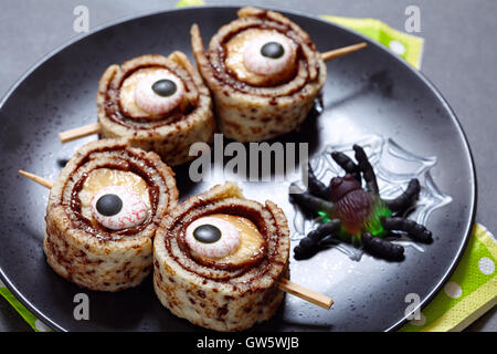 Les yeux de monstre pour Halloween. Rouler les crêpes à la banane Banque D'Images