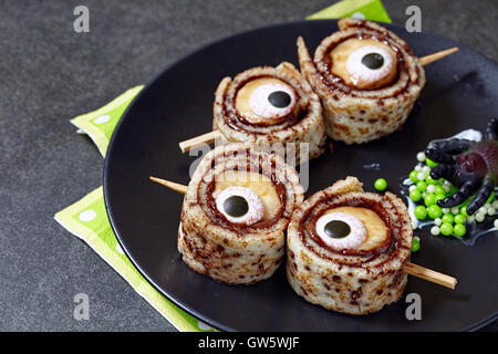 Les yeux de monstre pour Halloween. Rouler les crêpes à la banane Banque D'Images