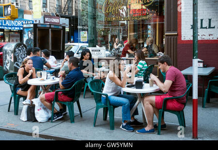 Les jeunes bénéficiant d'un café en plein air à la Caffe Roma dans la Petite Italie de New York City Banque D'Images