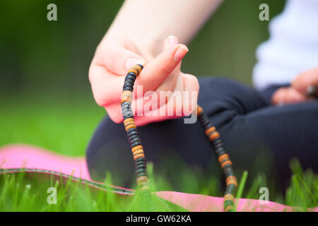 Close up of female hand holding rosary - concept de méditation. Banque D'Images