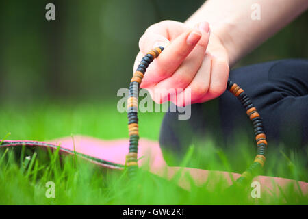 Close up of female hand holding rosary - concept de méditation. Banque D'Images