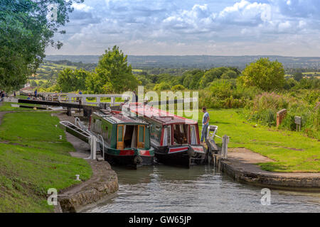 Barges colorées de quitter l'un des 16 Caen Hill locks sur le canal Kennet & Avon nr Devizes, Wiltshire, England, UK Banque D'Images