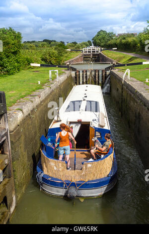 Une barge colorés en passant par l'un des 16 Caen Hill locks sur le canal Kennet & Avon nr Devizes, Wiltshire, England, UK Banque D'Images