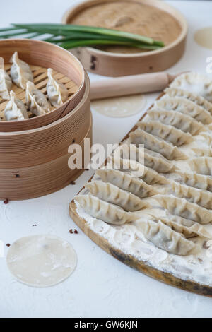 Des matières premières boulettes chinoises sur planche de bois. Banque D'Images