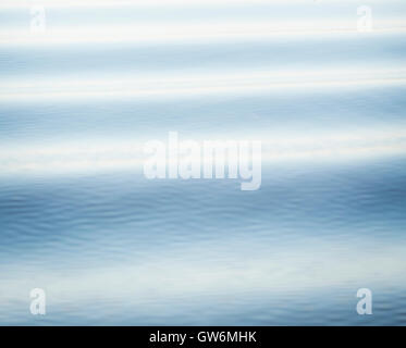 Surface lisse de l'eau avec de petites ondulations dans soft blue comme arrière-plan Banque D'Images