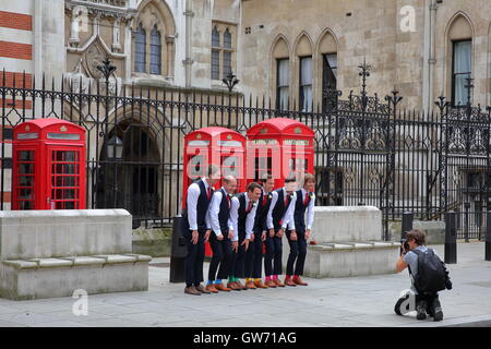 Six hommes posant devant une cérémonie de mariage sur Carey Street en face de la façade extérieure de Royal Courts of Justice, London, UK Banque D'Images