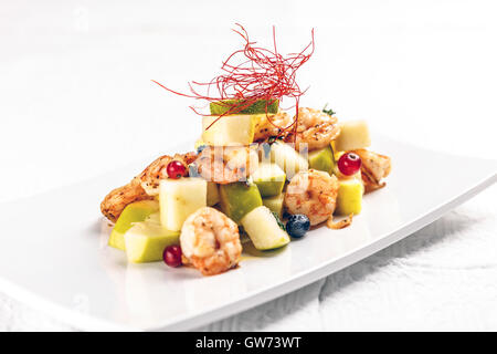 Les crevettes avec des fruits sur plaque blanche dans le restaurant Banque D'Images