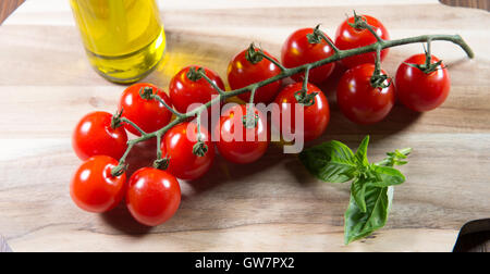 Bouquet de tomates cerise sur un fond de bois et d'huile Banque D'Images