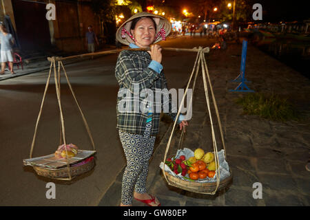 Femme transportant vietnamiens produisent sur un bambou chape, Hoi An (Site du patrimoine mondial de l'UNESCO), Vietnam Banque D'Images