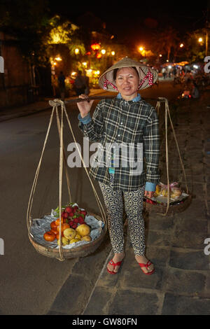 Femme transportant vietnamiens produisent sur un bambou chape, Hoi An (Site du patrimoine mondial de l'UNESCO), Vietnam Banque D'Images