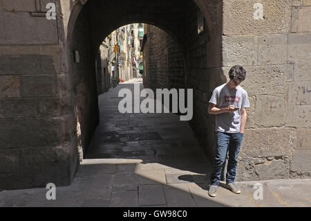 Un adolescent en utilisant son téléphone à Barcelone Banque D'Images