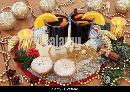 Noël encore la vie scène avec gold glitter joie signe, vin chaud, mince pies, décorations babiole, des bougies, des fruits et d'épices. Banque D'Images