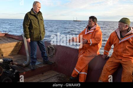 Le président russe Vladimir Poutine parle avec les pêcheurs au cours d'une visite à l'île de Lipno et lac Ilmen 10 Septembre, 2016 dans oblast de Novgorod, en Russie. Poutine et le premier ministre Dmitri Medvedev a rejoint les pêcheurs lors d'une sortie et a observé l'ancien style de glisser-techniques de pêche au filet. Banque D'Images