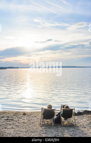 Übersee (Chiemgau) : le lac de Chiemsee, plage du lido, les gens de chaises de plage, Coucher de soleil, l'Allemagne, Bavière, Bayern, Oberbayern, Chiemga Banque D'Images