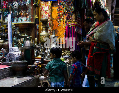 Muscat, Oman, 19 Octobre 2013 : Une mère et ses deux fils dans la nuit dans un magasin à Mascate, à l'intérieur du souk de Mutrah à Mascate. Banque D'Images