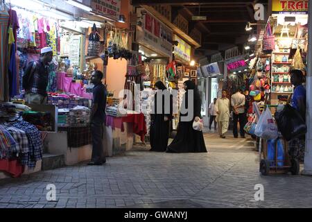 Muscat, Oman, 19 Octobre 2013 : Le souk de Mutrah, la nuit. Les femmes musulmanes regarde la boutique avec le voile islamique typique Banque D'Images