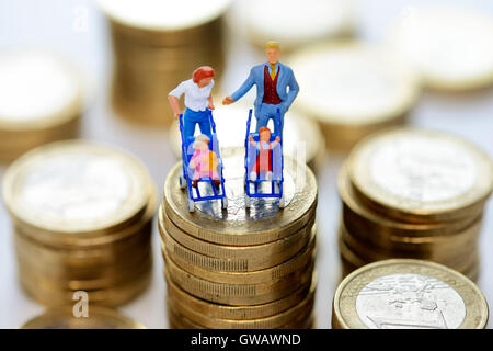 Figures miniatures d'une famille sur une pièce de velours, de la famille, de l'argent photo symbolique von Miniaturfiguren Muenzstapel Familie auf einem, Banque D'Images