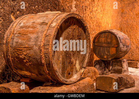 Old oak barrel avec rusty arceaux. Cave à vin profond avec des murs texturés Banque D'Images