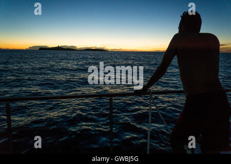 Les gens de voile à la recherche à l'île de Santa Barbara, Abrolhos Marine National Park, Bahia, Brésil, pendant l'heure du coucher du soleil Banque D'Images