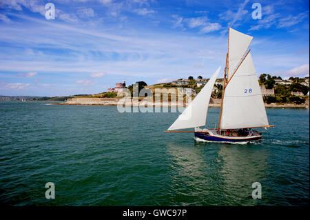 Un yacht quitte le port de St Mawes passé le château construit par Henri VIII sur une belle journée d'été à Cornwall. Banque D'Images