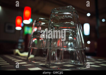 Photo gros plan de verres vides empilées sur table en barre sombre. Selective focus Banque D'Images
