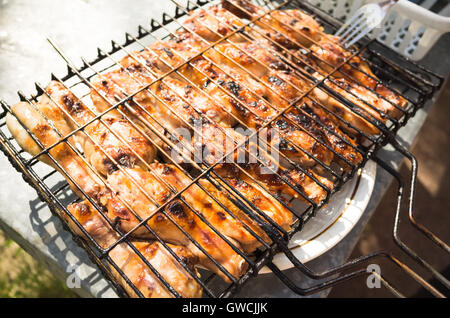 Pilons de poulet grillé en grille de métal Banque D'Images