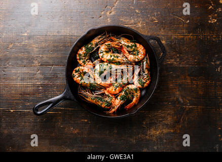 Crevettes géantes grillées sur le gril de cuisson avec la sauce verte sur fond de bois Banque D'Images
