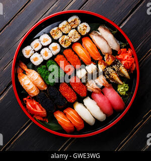 Set de sushis nigiri gunkan, rouleaux et servi dans le Japon traditionnel plaque ronde Sushioke noir Banque D'Images