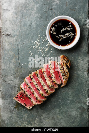 Tranches de steak de thon grillé au sésame et de la sauce soja sur conseil ardoise Banque D'Images