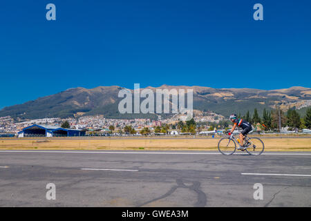 QUITO, ÉQUATEUR - marzo 23, 2015 : Sur la route d'un cycliste non identifiés et de formation très belle vue derrière lui, journée ensoleillée et complète Banque D'Images