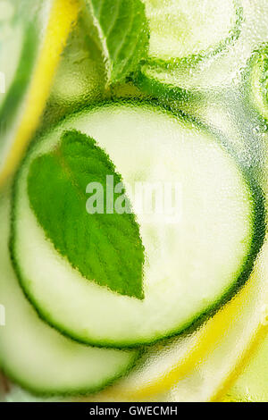 L'eau infusée avec le concombre, citron, citron vert et menthe sur fond bleu Banque D'Images