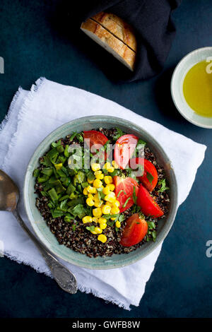 Poblano rôtis le quinoa garni de tomates, de maïs et de coriandre. Servi avec de l'huile d'olive et du pain. Photographié en vue de dessus sur un Banque D'Images