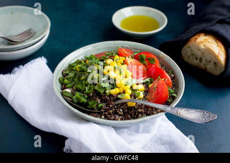 Poblano rôtis le quinoa garni de tomates, de maïs et de coriandre. Servi avec de l'huile d'olive et du pain. Photographié en vue de dessus sur un Banque D'Images