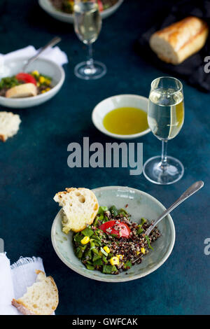 Poblano rôtis le quinoa garni de tomates, de maïs et de coriandre. Servi avec du vin blanc, huile d'olive et du pain. Photographié à partir de la f Banque D'Images