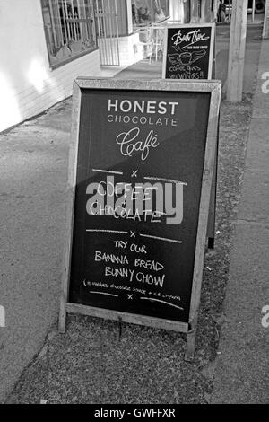 Café Chocolat honnête pancarte sur la chaussée dans Wale Street, Cape Town, Afrique du Sud.(noir et blanc) Banque D'Images