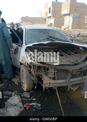 (160913) -- QUETTA, 13 septembre 2016 (Xinhua) -- les gens examinent une voiture endommagée lors d'une explosion au Pakistan Quetta du site le 13 septembre 2016. Au moins deux policiers ont été tués et huit autres blessés dans une explosion à proximité d'un véhicule de police dans le sud-ouest du Pakistan Quetta ville mardi après-midi, les médias ont rapporté l'ourdou. (Xinhua/Irfan) Banque D'Images