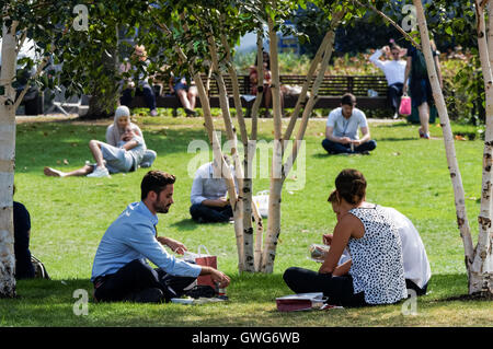 Les personnes bénéficiant du beau temps dans les champs de potiers parc à côté de l'hôtel de ville, Londres Angleterre Royaume-Uni UK Banque D'Images