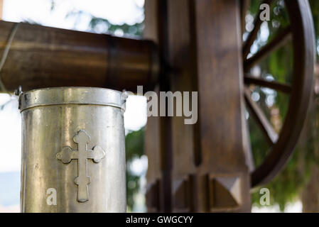 Ancien puits avec de l'eau potable et un seau en métal avec croix de signer au monastère de Capriana en Moldavie Banque D'Images