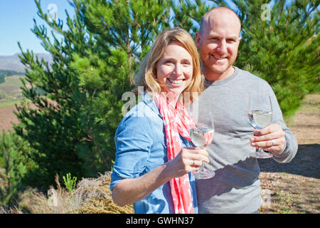 Smiling couple avec du vin en plein air Banque D'Images