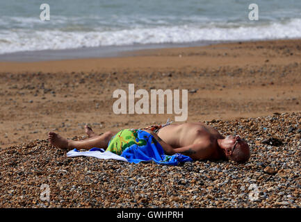 Un homme jouit du beau temps sur la plage de Brighton, East Sussex, comme aujourd'hui pourrait être le jour de septembre le plus chaud depuis plus de 50 ans. Banque D'Images