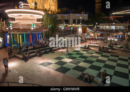 Au carrousel 100 yr old vintage amusement park sur la colline de Tibidabo dans la nuit avec un échiquier géant au premier plan. Banque D'Images