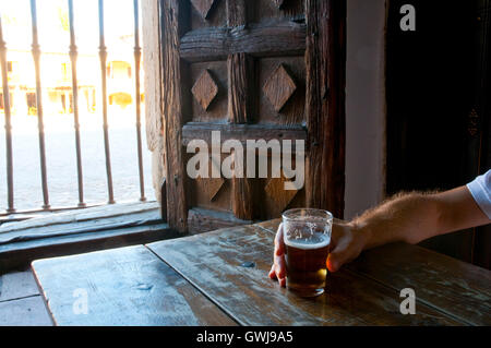 L'homme de boire un verre de bière dans une taverne. Pedraza, province de segovia, Castilla Leon, Espagne. Banque D'Images